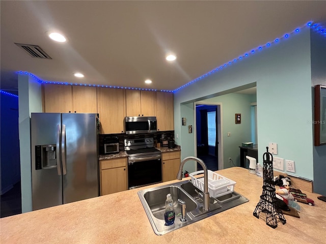 kitchen featuring tasteful backsplash, sink, and appliances with stainless steel finishes