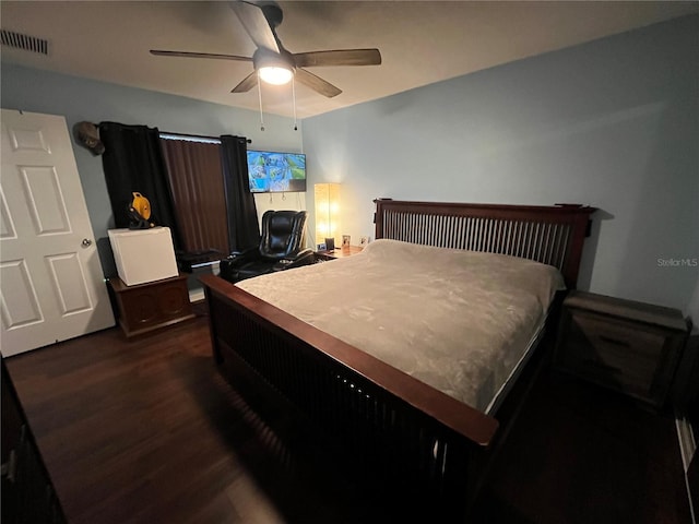 bedroom with dark hardwood / wood-style flooring and ceiling fan