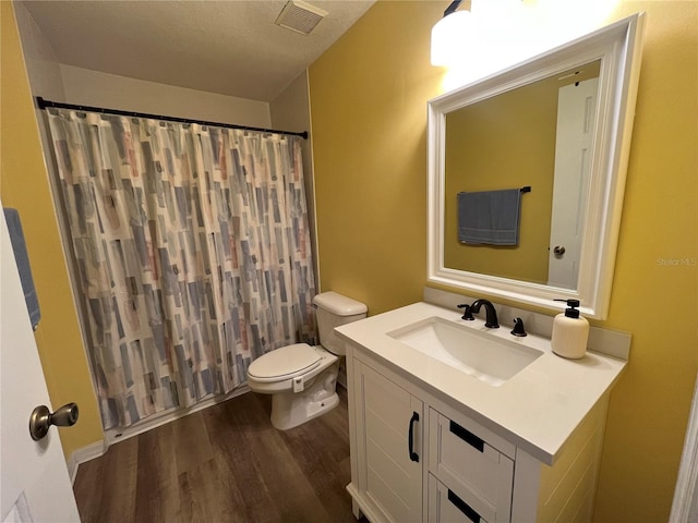 bathroom featuring vanity, hardwood / wood-style flooring, a textured ceiling, and toilet