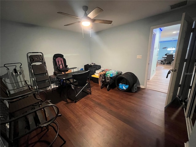 home office with dark hardwood / wood-style flooring and ceiling fan