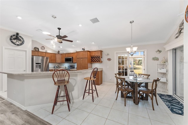 dining area featuring ornamental molding, lofted ceiling, ceiling fan with notable chandelier, and light tile patterned floors