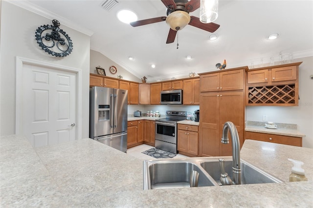 kitchen featuring light tile patterned flooring, sink, vaulted ceiling, ornamental molding, and stainless steel appliances