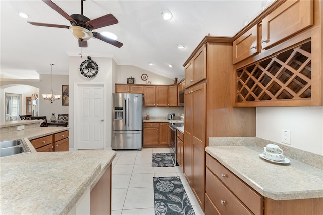 kitchen with vaulted ceiling, light tile patterned floors, ornamental molding, appliances with stainless steel finishes, and pendant lighting