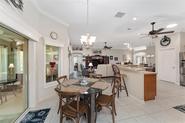 dining space featuring crown molding, ceiling fan with notable chandelier, and light tile patterned flooring