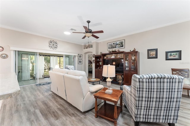 living room featuring crown molding, ceiling fan, and light hardwood / wood-style flooring