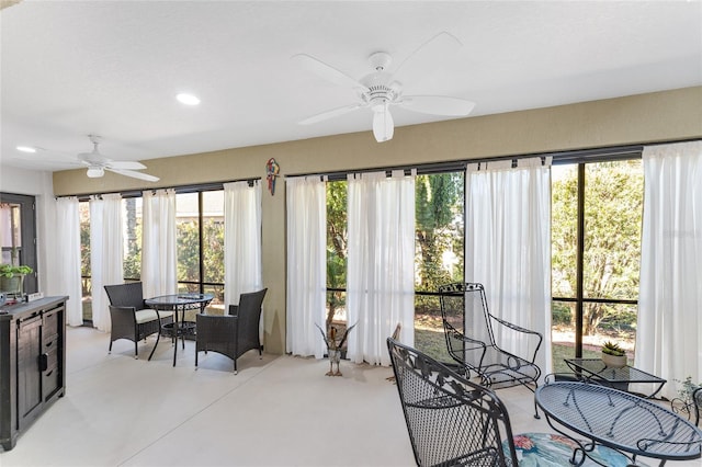 sunroom featuring ceiling fan and plenty of natural light