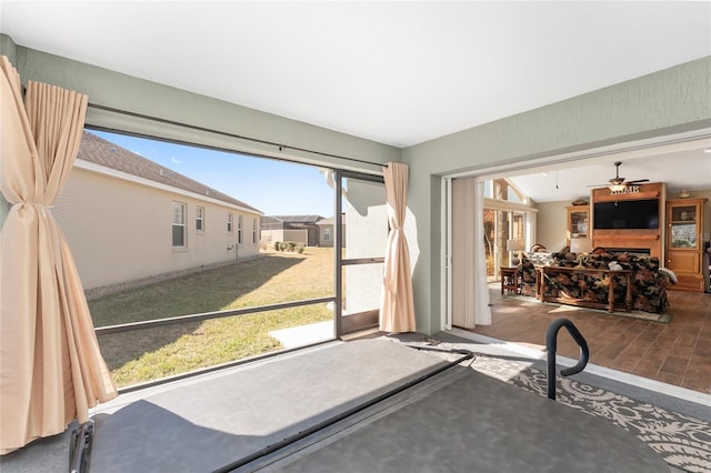 doorway to outside featuring hardwood / wood-style flooring, vaulted ceiling, a fireplace, and ceiling fan