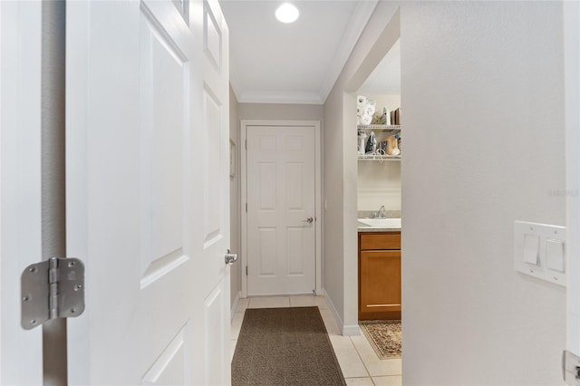 hall featuring ornamental molding, sink, and light tile patterned floors