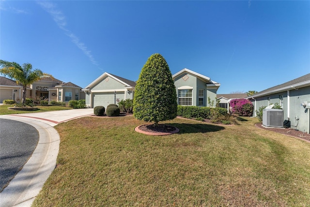 view of front of home featuring a garage, central AC, and a front yard