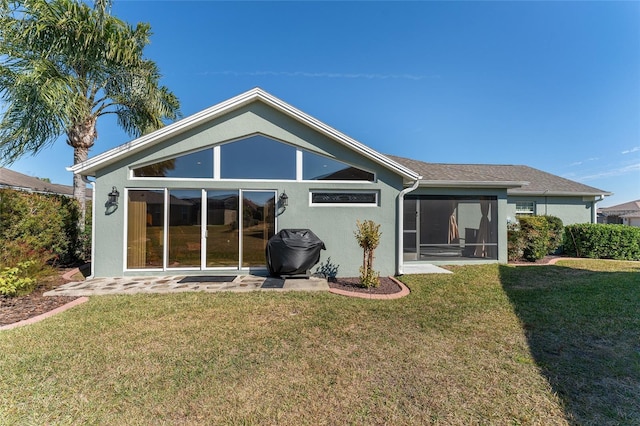 back of house featuring a lawn and a sunroom