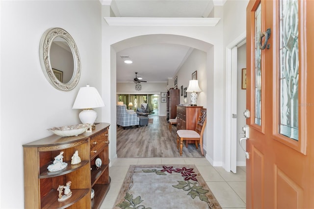 entryway featuring crown molding, light tile patterned floors, and ceiling fan