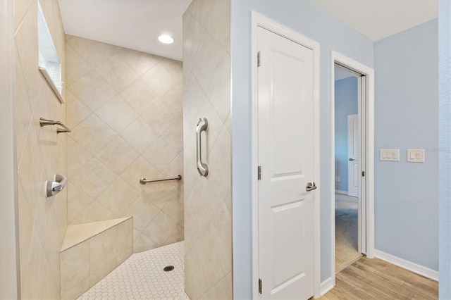 bathroom featuring hardwood / wood-style flooring and tiled shower