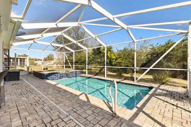 view of pool featuring an in ground hot tub, a patio area, and glass enclosure