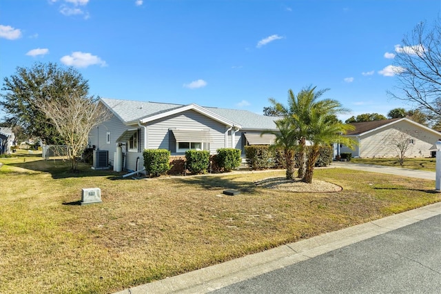 ranch-style home featuring cooling unit and a front yard