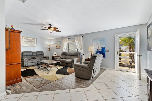 tiled living room with ceiling fan, a healthy amount of sunlight, and a textured ceiling