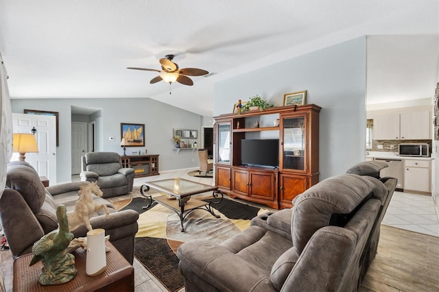 living room with ceiling fan, vaulted ceiling, and light hardwood / wood-style flooring