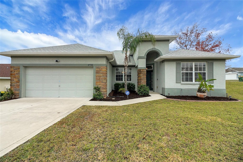 view of front of property with a garage and a front lawn