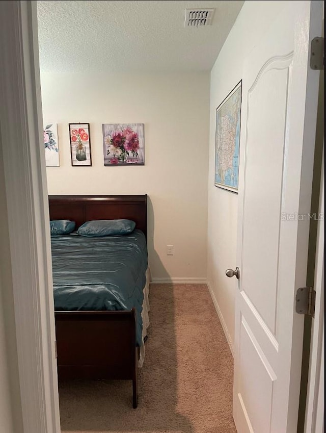 bedroom featuring carpet floors and a textured ceiling