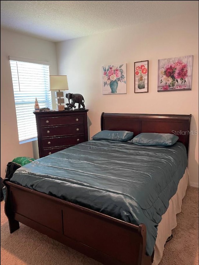 carpeted bedroom featuring a textured ceiling