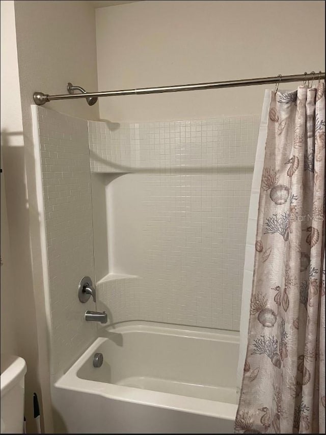 bathroom featuring toilet and shower / bath combo with shower curtain