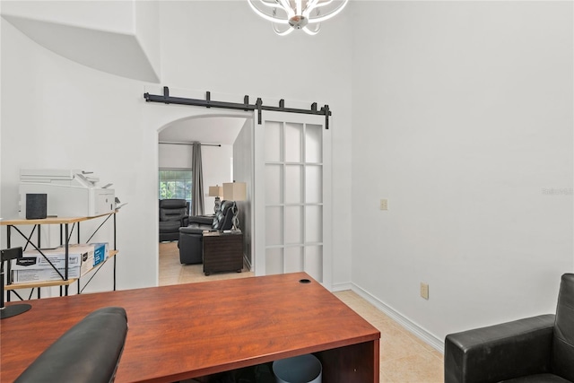 office featuring an inviting chandelier, light tile patterned floors, and a barn door