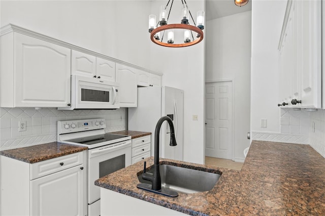 kitchen with sink, white appliances, white cabinets, and backsplash