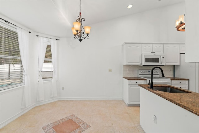 kitchen with light tile patterned floors, white appliances, tasteful backsplash, white cabinets, and decorative light fixtures