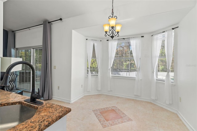 tiled dining space featuring sink and a chandelier