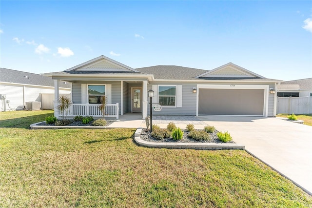 view of front of house with a porch, a garage, central AC unit, and a front lawn