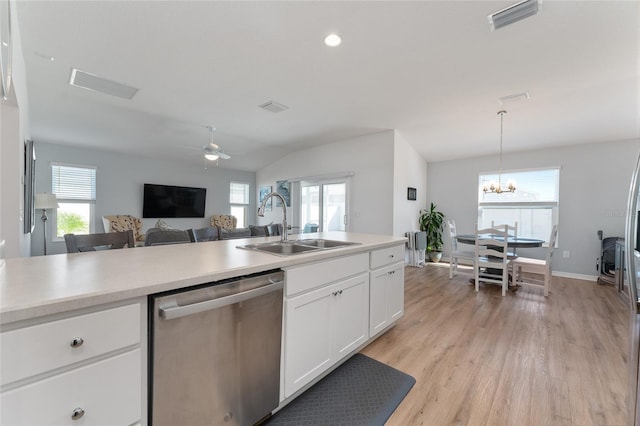 kitchen with lofted ceiling, sink, white cabinets, hanging light fixtures, and stainless steel dishwasher