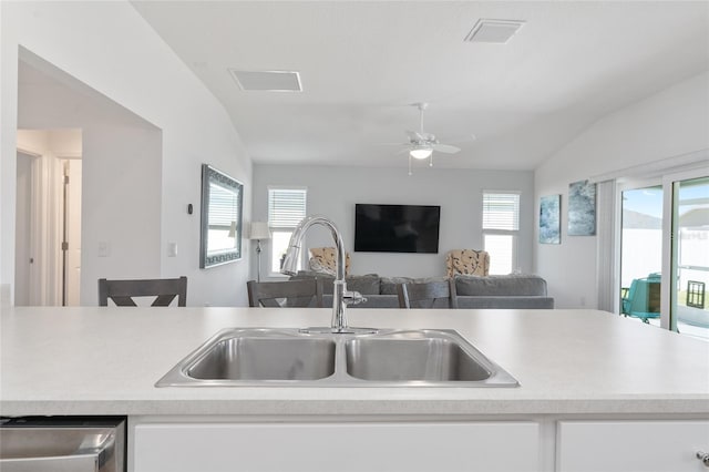 kitchen with white cabinetry, stainless steel dishwasher, lofted ceiling, and sink