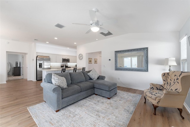 living room with ceiling fan, lofted ceiling, and light wood-type flooring