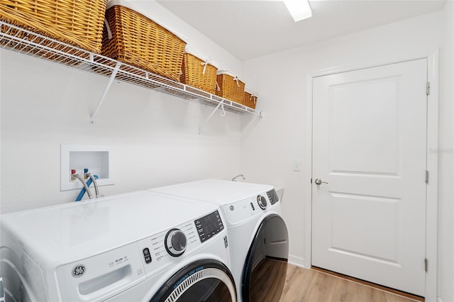 washroom featuring washer and clothes dryer and light hardwood / wood-style floors