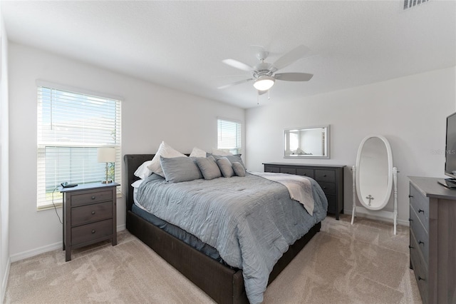 carpeted bedroom with multiple windows and ceiling fan