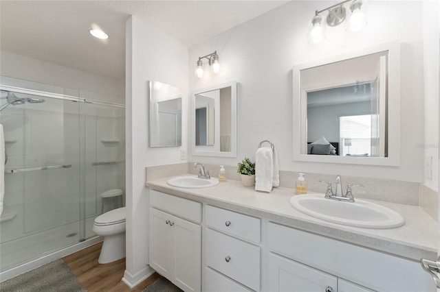 bathroom featuring vanity, toilet, an enclosed shower, and hardwood / wood-style floors