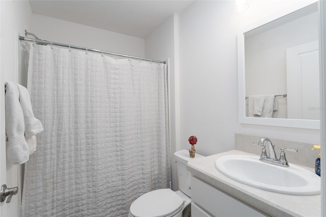 bathroom with vanity, curtained shower, and toilet