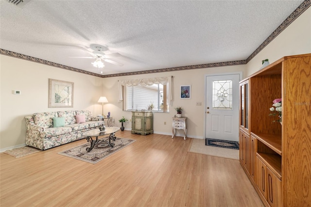 living room with ceiling fan, light hardwood / wood-style flooring, and a textured ceiling