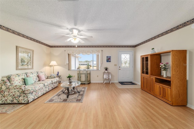 living room featuring ceiling fan, a textured ceiling, and light hardwood / wood-style flooring