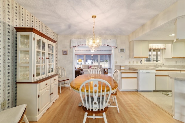 dining room featuring a chandelier, light hardwood / wood-style floors, and a textured ceiling