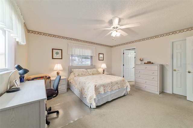 carpeted bedroom featuring a textured ceiling and ceiling fan