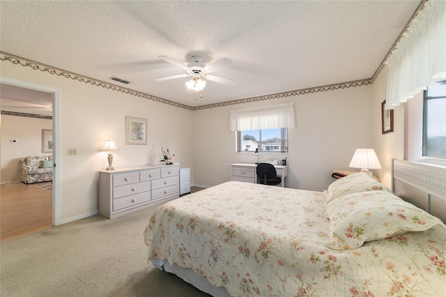 carpeted bedroom with a textured ceiling and ceiling fan