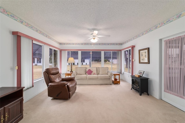 carpeted living room with ceiling fan, a textured ceiling, and a wood stove