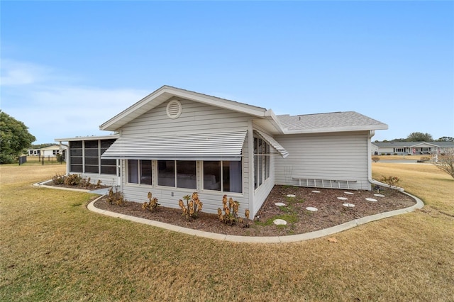 rear view of property with a sunroom and a lawn