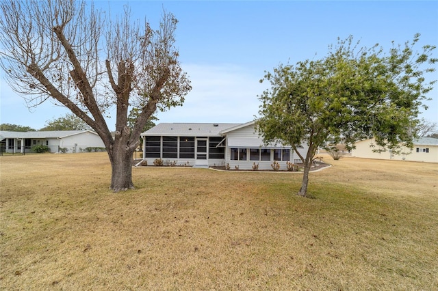 back of house with a lawn and a sunroom