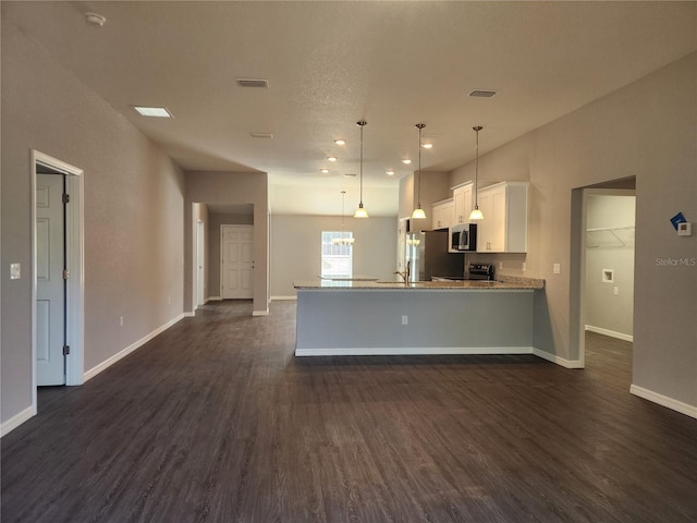 kitchen with stainless steel appliances, hanging light fixtures, white cabinets, and dark hardwood / wood-style flooring