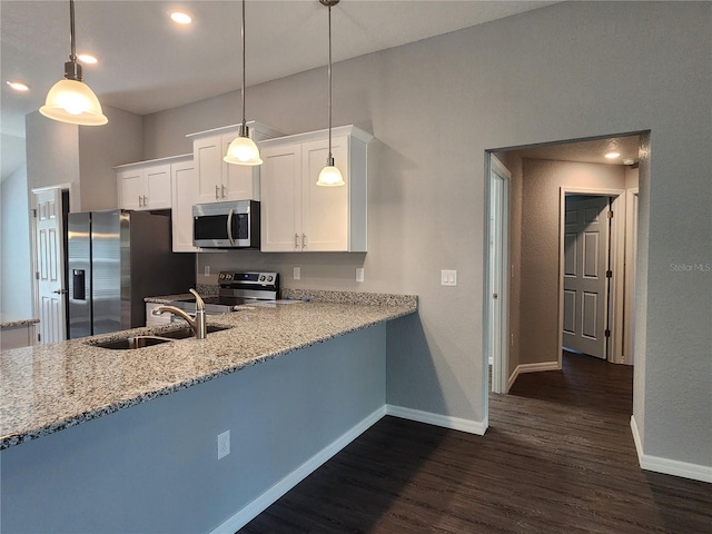 kitchen with appliances with stainless steel finishes, pendant lighting, white cabinetry, sink, and light stone counters