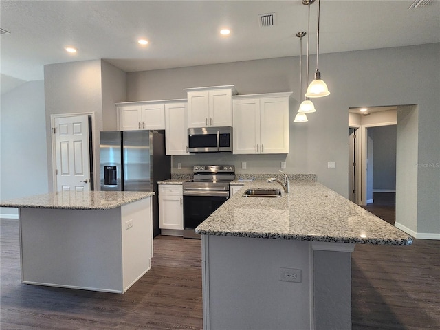 kitchen with decorative light fixtures, sink, white cabinets, kitchen peninsula, and stainless steel appliances