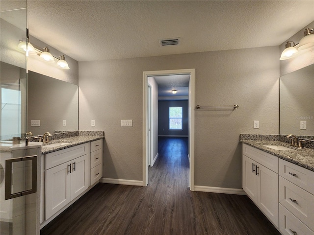 bathroom featuring vanity, hardwood / wood-style flooring, and a textured ceiling