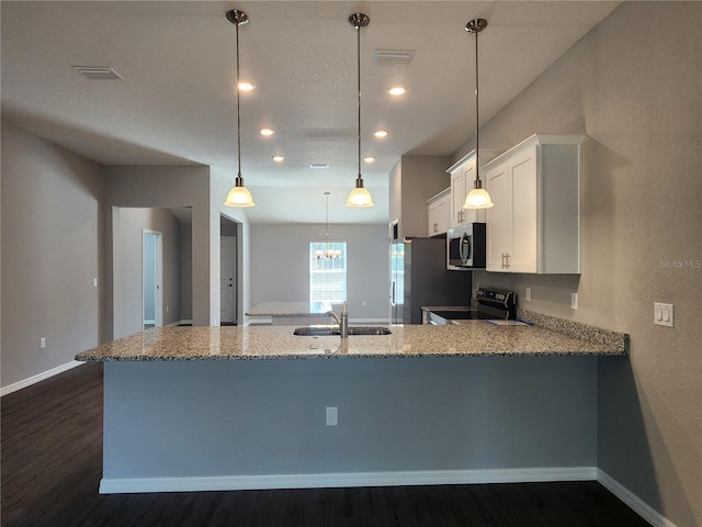 kitchen with sink, appliances with stainless steel finishes, hanging light fixtures, white cabinets, and kitchen peninsula