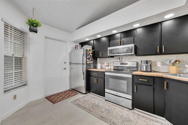 kitchen with lofted ceiling, stainless steel appliances, a textured ceiling, and backsplash